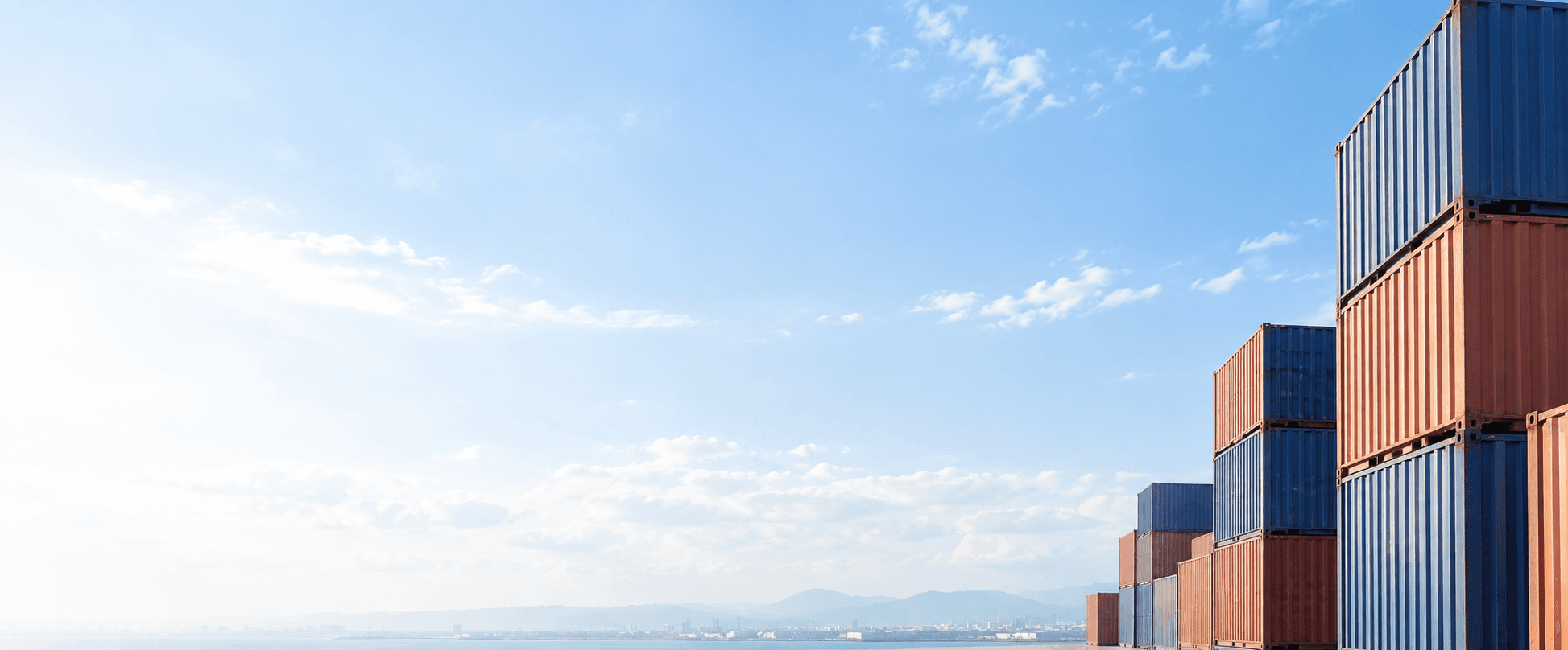 Freight containers beneath a clear sky in an international shipping yard